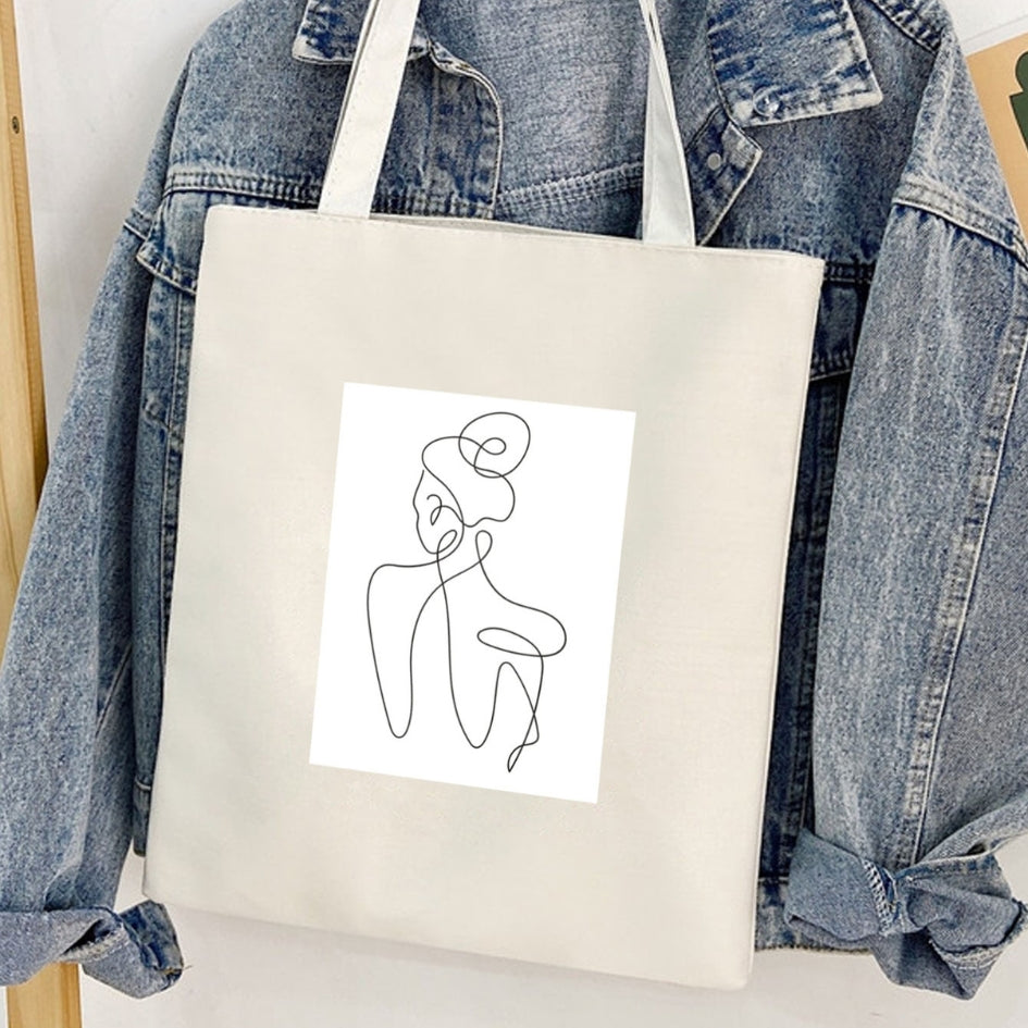 Torba płócienna Kiskedves Line Art z postacią od tyłu, przed jeansową kurtką.