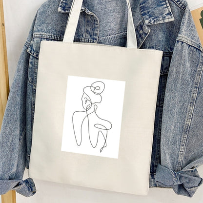 Torba płócienna Kiskedves Line Art z postacią od tyłu, przed jeansową kurtką.