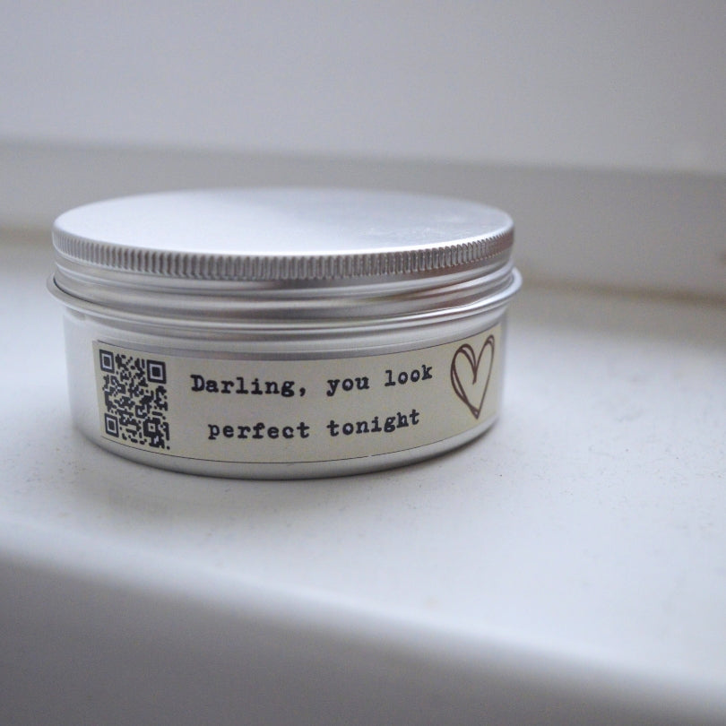 Świeca Kiskedves „Melodyjna” w metalowej puszce, na etykiecie kod QR i napis „Darling, you look perfect tonight”.