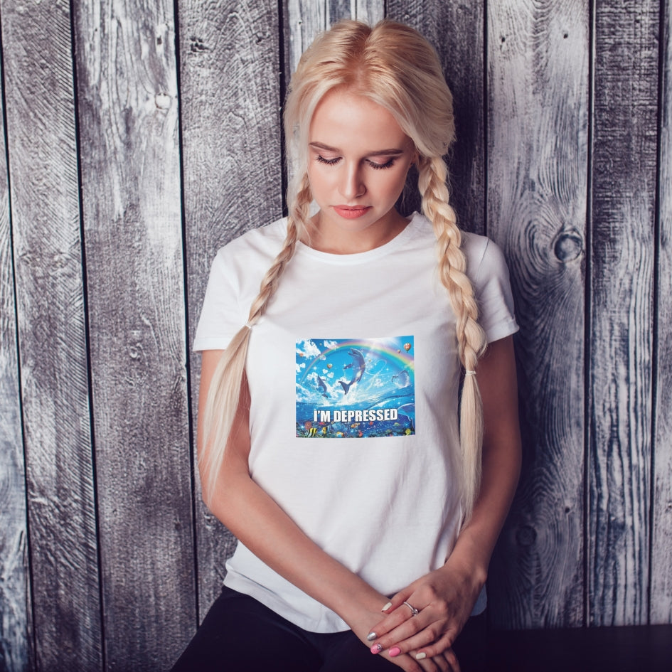 Koszulka Kiskedves I'm depressed ze skaczącymi delfinami, tęczą i napisem I'M DEPRESSED, na białej koszulce.