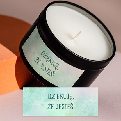 Świeca prezentowa Kiskedves z 1. etykietą i etykieta powiększona obok: zielonkawy akwarelowy wzór mandali z napisem „DZIĘKUJĘ, ŻE JESTEŚ!”