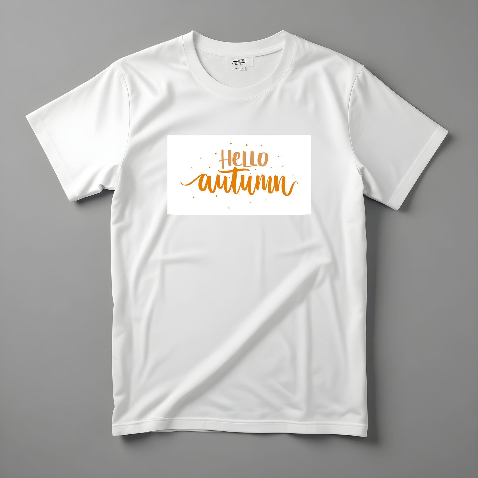 Koszulka Kiskedves Hello Autumn z pomarańczowym, odręcznym napisem Hello autumn i drobnymi kropkami, sfotografowana na płasko.
